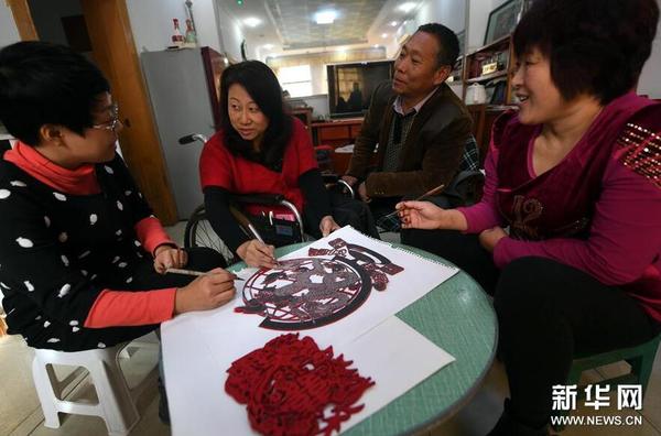 11月22日，刘彩霞（左二）向学员教授剪纸技艺。