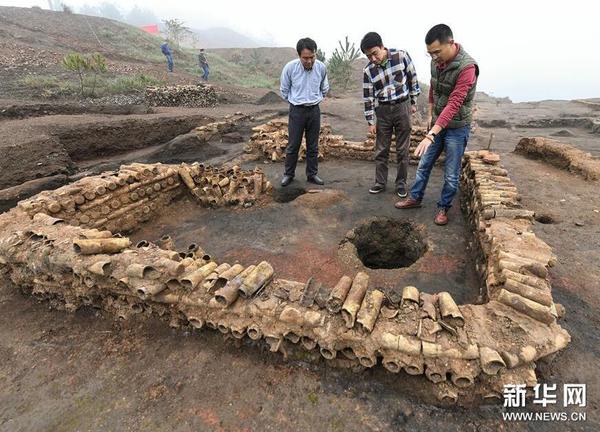 在桐木岭矿冶遗址，考古人员查看用废弃坩埚垒筑的房屋遗址（11月18日摄）。