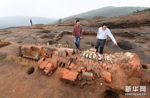 在桐木岭矿冶遗址，考古工作者在查看一个槽形冶炼炉（11月18日摄）。