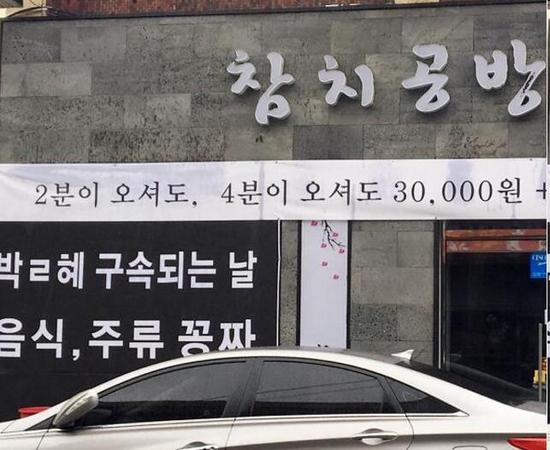 韩饭店挂倒朴标语：朴槿惠被捕之日食品酒水全免