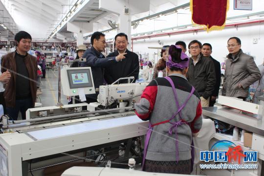 汤桂荔(前排左三)深入桂林溢达纺织有限公司生产车间视察。　陆汉宝 摄