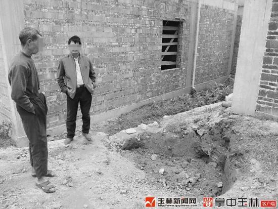 村民苏某兴（左）说，木材就是在这泥坑挖到的