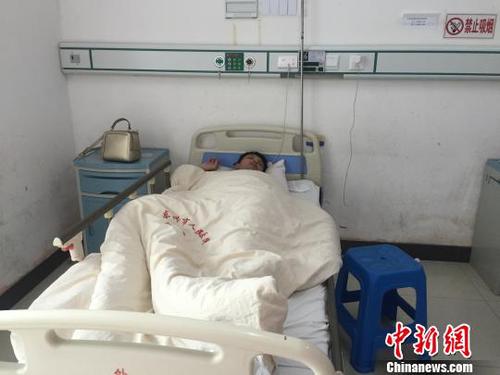 2月12日，广西东兴市人民医院住院部病房内，遭越南边防人员殴打致伤的中国游客谢某躺在病床上。　陈燕 摄