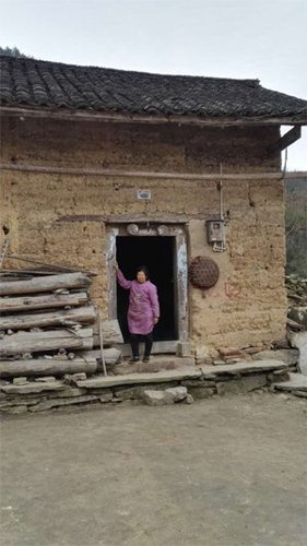 姚永胜老家的房子，他的母亲站在门口，还不知道儿子死亡的消息。图片由村民提供