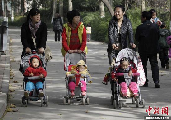 资料图：2013年11月15日，河南郑州几位家长推着婴儿车走过郑州街头。中共十八届三中全会审议通过了《中共中央关于全面深化改革若干重大问题的决定》，《决定》提出，启动实施一方是独生子女的夫妇可生育两个孩子的政策。<a target='_blank' href='http://www.chinanews.com/'>中新社</a>发 王中举 摄