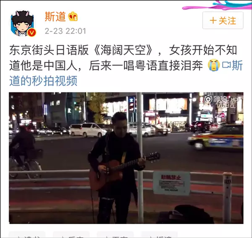 东京街头，一名男子抱着吉他，用日语自弹自唱经典老歌《海阔天空》，熟悉的旋律吸引了一个女孩驻足聆听。