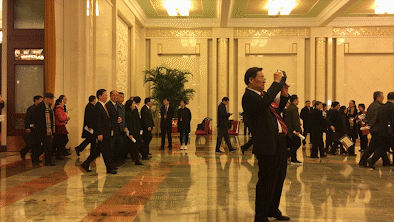 2017年3月5日，第十二届全国人民代表大会第五次会议在北京人民大会堂开幕。会议结束后代表离场，一名代表举起手机拍照纪念。