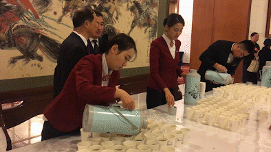 2017年3月5日，第十二届全国人民代表大会第五次会议在北京人民大会堂开幕。人民大会堂，服务人员在倒水，其中一名男性服务人员在忙碌中得空伸了伸腰。