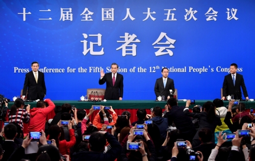 3月8日，十二届全国人大五次会议新闻中心举行记者会，邀请外交部部长王毅就“中国的外交政策和对外关系”的相关问题回答中外记者的提问。这是王毅（左二）向记者挥手致意。新华社记者 李鑫摄