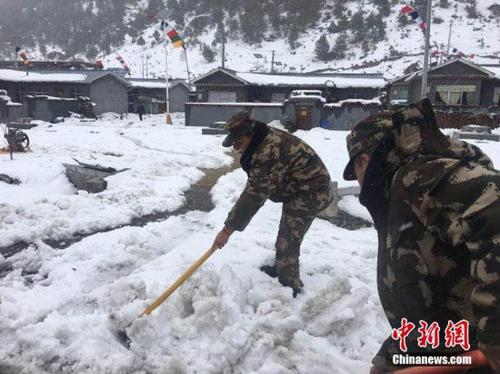 3月11日，西藏公安边防总队机动支队应急二分队官兵正在铲除道路积雪。 张钰 摄
