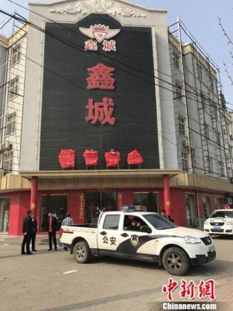 在雄县鑫城小区的售楼处，玻璃大门已被贴上封条。一辆警车和一辆城管车停放在售楼处门口。　肖光明 摄