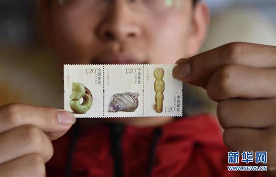 4月9日，集邮爱好者在展示《红山文化玉器》特种邮票