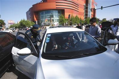 4月24日，交通执法人员在朝阳大悦城附近，对一辆非法营运车辆进行查处。新京报记者 王贵彬 摄