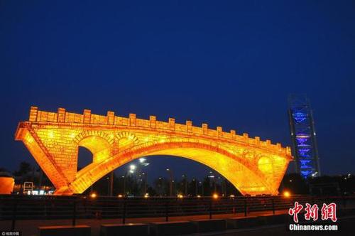 4月18日晚，北京奥林匹克公园，新建成的“丝路金桥”大型景观正在试灯，呈现出金碧辉煌的醉人景致， 迎接“一带一路”国际合作高峰论坛的到来。 杜佳 摄 图片来源：视觉中国
