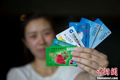 资料图：民众展示银行卡。 <a target='_blank' href='http://www.chinanews.com/'>中新社</a>记者 张云 摄