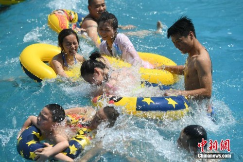 资料图：5月27日，重庆洋人街一水上乐园吸引不少市民玩水纳凉。当日，重庆主城区室外最高气温逼近35℃。 陈超 摄