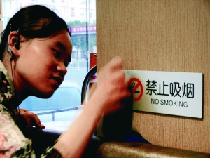 昨日，在北京西城某餐厅店员正在擦拭禁止吸烟标志。北京晨报记者 姜浩波/摄