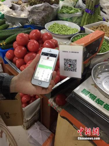 资料图：市民买个菜都离不开手机流量结账。中新网 吴涛 摄