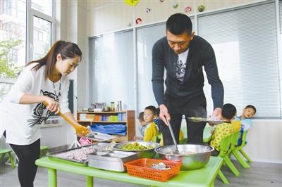 逄秋香、陈亮夫妻俩为幼儿园孩子盛午饭。