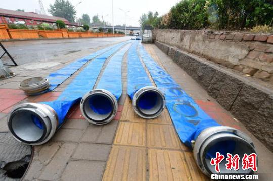 北京地区于21日午后陆续迎来降水。北京市通州区组建了19支应急抢险队伍，8582名应急抢险人员随时待命。图为通州区相关部门进行排水。　常鸣 摄