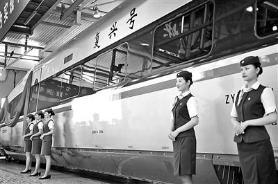 乘务人员站在“复兴号”中国标准动车组CR400AF型列车旁供图/新华社