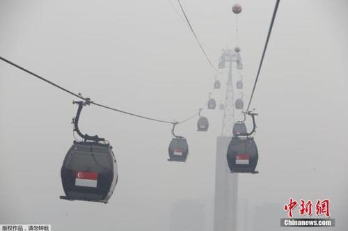 当地时间9月29日，新加坡依旧笼罩在雾霾之中，从高空俯瞰下去，城市陷入一片朦胧之中。通往旅游区的观光缆车在雾霾中正常运转，但往日美景已经看不到了。