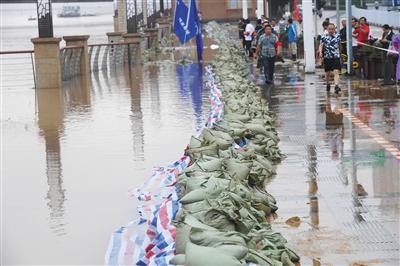 2日，工作人员在长沙城区湘江沿岸搬运沙袋加固子堤。 新华社记者 龙弘涛 摄