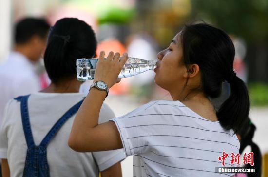 7月6日，新疆乌鲁木齐市最高温度达到36摄氏度，一位市民躲在阴凉处大口喝水。 <a target='_blank' href='http://www.chinanews.com/'>中新社</a>记者 刘新 摄