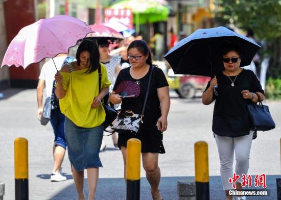 7月6日，新疆乌鲁木齐市最高温度达到36摄氏度，外出民众打着伞。 <a target='_blank' href='http://www.chinanews.com/'>中新社</a>记者 刘新 摄