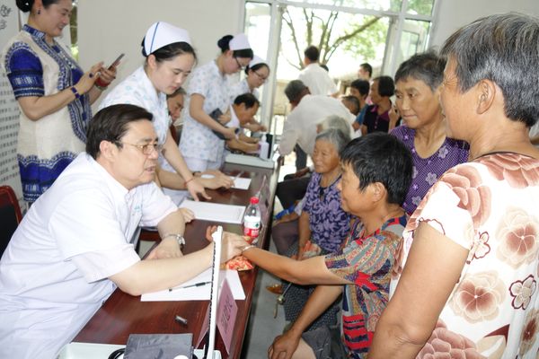 温建民委员在龙林村民委员会给贫困患者看病。