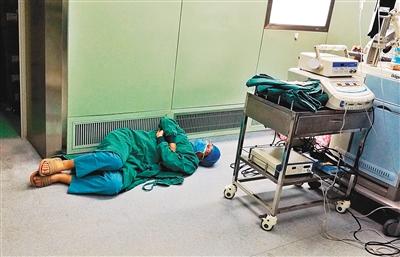 连续工作了近24小时的儿童医院神经外科大夫在手术间隙，躺在手术室的地板上休息。 西安晚报首席记者王健 摄
