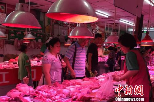 北京陶然亭公园附近一家农贸市场内，正有消费者在挑选五花肉。<a target='_blank' href='http://www.chinanews.com/' >中新网</a> 种卿 摄