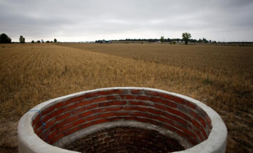 在西班牙阿雷瓦洛的一处农田，高温已造成农作物一片枯黄，连水井也干枯了。（路透社）