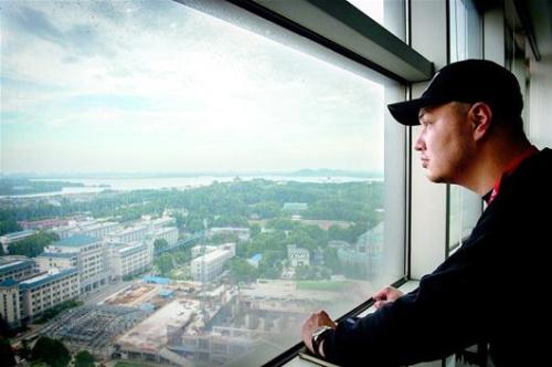 图为陈强在办公室远眺武汉，眺望他和弟弟妹妹在武汉的美好未来。
