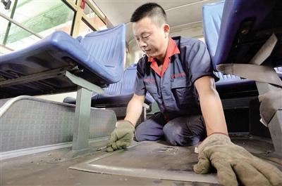 7月16日，五里店公交车修理厂，李元兵师傅在高温天里检修车辆。本报记者 胡杰 摄