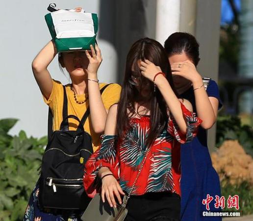 7月20日，武汉高温持续，出行的市民用手和随身物品遮挡阳光。<a target='_blank' href='http://www.chinanews.com/'>中新社</a>记者 张畅 摄