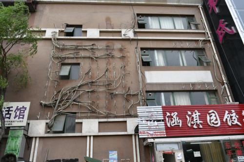 拆除空调外机后的墙面，仍可以依稀看到之前挂满外机的痕迹。北京市消防局 供图