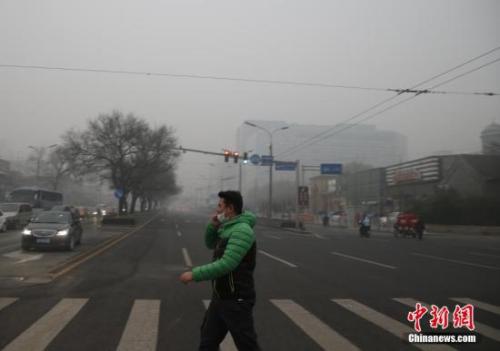 资料图：一名戴着口罩的行人走在北京街头。<a target='_blank' href='http://www.chinanews.com/'>中新社</a>记者 张浩 摄