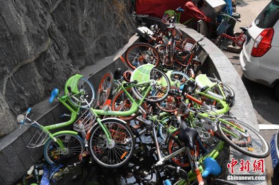 资料图：山西太原一小区内10余平方米的水池里被堆放了约70辆共享单车。武俊杰 摄