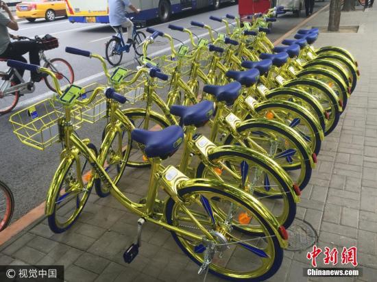 资料图：6月8日，北京，金色共享单车现身朝阳区望京街头。该共享单车配备充电模块，可以给手机充电。 图片来源：视觉中国