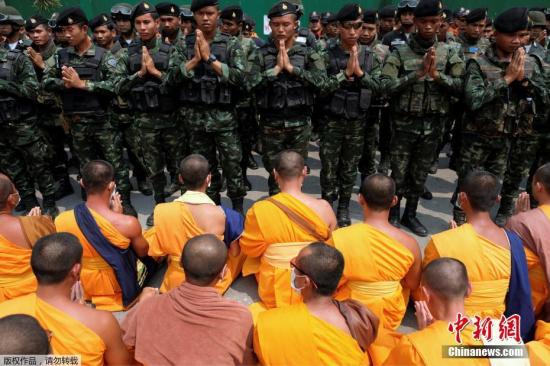 资料图：3月9日，泰国军方和警方出动多名工作人员试图进入法身寺搜查，超过众多僧侣站在桥上组成“人墙”，阻止工作人员进入。