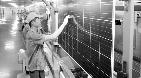 安徽滁州一家企业的太阳能电板生产流水线上，工人们对产品进行检测。  新华社发