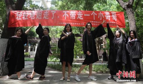 6月9日，几名毕业生在北京工业大学校园内合影，校园里悬挂着北京部分高校毕业季里特有的“任性”条幅。<a target='_blank' href='http://www.chinanews.com/'>中新社</a>记者 杨可佳 摄