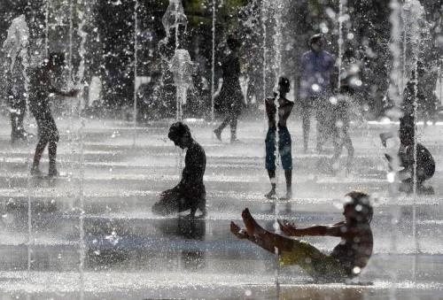去年是有纪录以来最热的一年，图为法国尼斯的民众在喷泉嬉水消暑。（图片来源：法新社）
