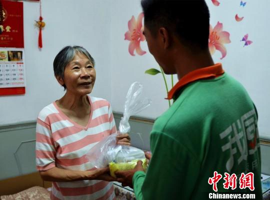 居民张惠珍接受“爱心食物包”。　王子涛 摄