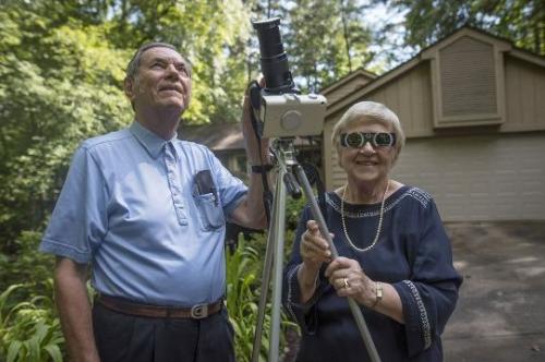 美国克雷门森大学退休教授李本博格(左)看过26次日全食，他与妻子诺玛8月17日在南卡州萨冷自家车道上。(图片来源： 美联社)