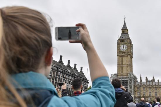 8月21日，在英国伦敦，一名游客在拍摄“大本钟”。新华社发（史蒂芬·程摄）