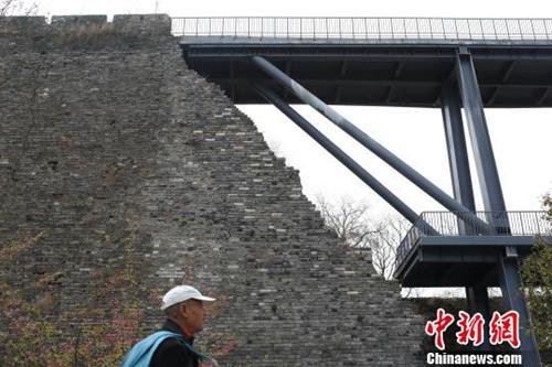 资料图：南京650岁古城墙“植入”了灰色的现代钢结构桥梁。　泱波 摄