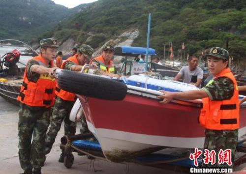 图为温州公安边防官兵帮民众转移船只。王华 摄