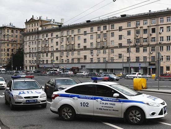 9月13日，两辆警车停在莫斯科一进行疏散的购物中心外。（新华/卫星社）
